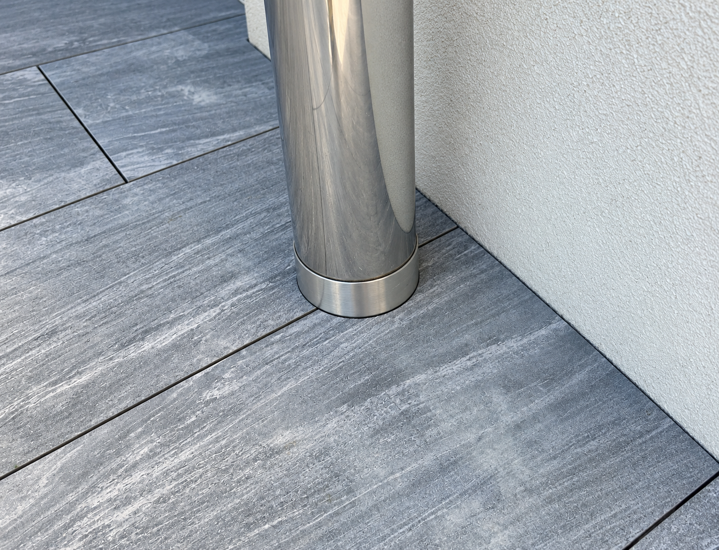 Grey Tiles Framing a Stainless Downpipe
