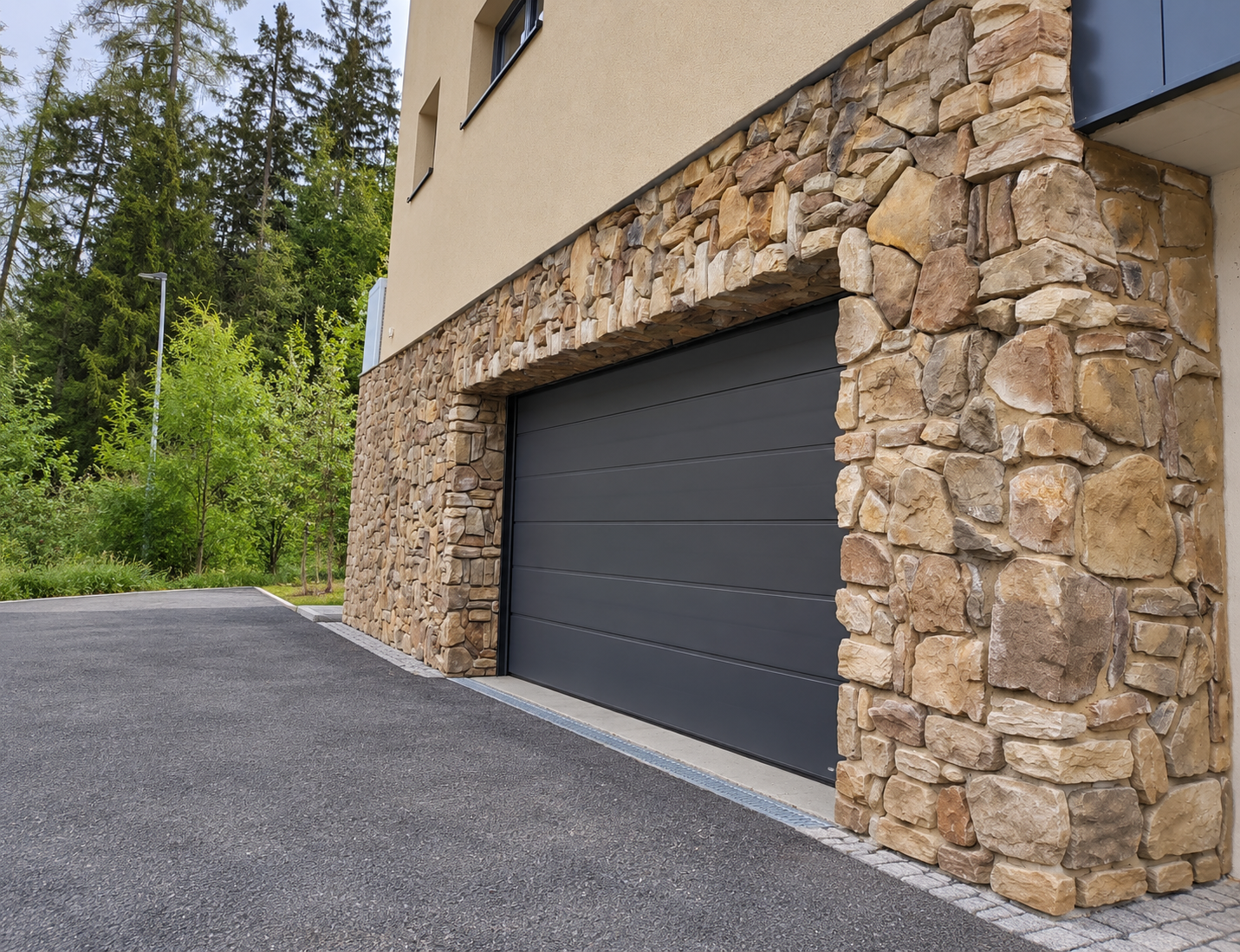 Stone garage with forest driveway